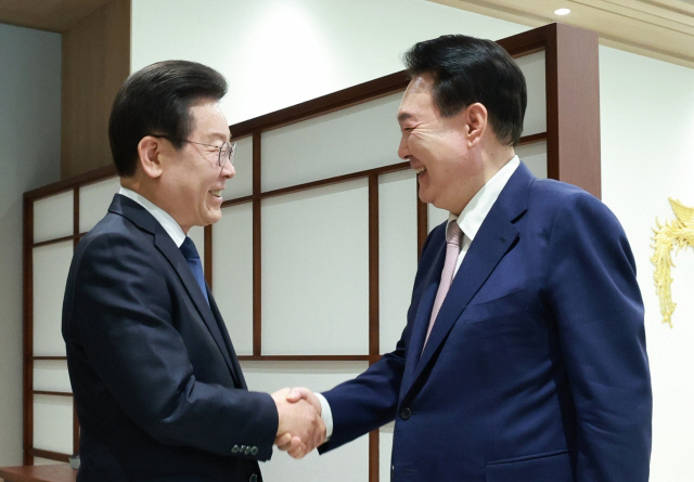 윤석열 대통령이 29일 서울 용산 대통령실에서 열린 영수회담에서 집무실에 도착한 이재명 더불어민주당 대표를 맞이하며 악수하고 있다. <연합뉴스>